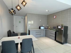 a kitchen with a table and some chairs in a room at Sunway City Ipoh Tambun Onsen Cozy Retreat 8pax in Tambun