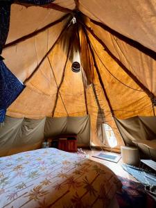 PuttyCosy Teepee to reconnect with Nature!的帐篷内的一个床位房间