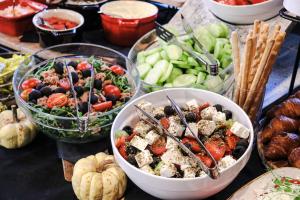 a table topped with bowls of food and vegetables at Amsterdam Hotel in Belgrade
