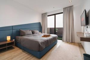 a bedroom with a blue bed and a large window at Lumi Tropicana Muji in Petaling Jaya +73 photos