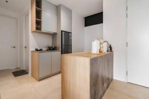 a kitchen with white cabinets and a wooden counter at Lumi Tropicana Muji in Petaling Jaya