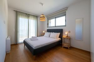 a bedroom with a bed and a large window at Cella Villa in Kalamata