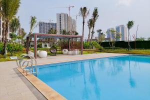 a large swimming pool with a gazebo next to a city at Fully Furnished with Pleasure 2BR at Sky House BSD Apartment By Travelio in Tangerang