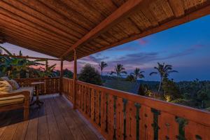 a deck with a view of the jungle at night at Umah Lusa in Munduk