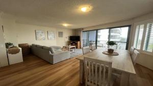 a living room with a couch and a table at Sandy Cove Unit 6 in Caloundra +6 photos