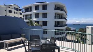 a balcony with a table and chairs and a building at Sandy Cove Unit 6 in Caloundra