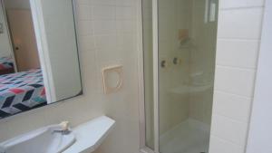 a bathroom with a shower and a sink and a mirror at Seamist Lodge Unit 5 in Caloundra +7 photos