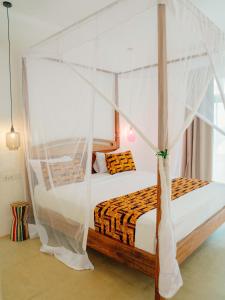 ein Schlafzimmer mit einem Himmelbett in der Unterkunft Heritage Sunset Retreat Zanzibar in Mchangani
