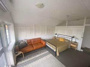 una sala de estar con un sofá y una cama en Magical Hardy's Bay Waterfront Apartment, en Killcare