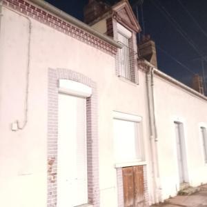 an old white building with two large doors at Paradis Maison Entière in Montargis