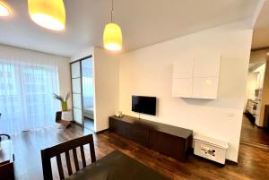 un soggiorno con armadi bianchi e TV a parete di Zygio Apartamentai a Vilnius
