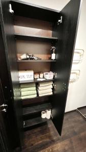 un armadio con una porta nera con asciugamani e scarpe di Zygio Apartamentai a Vilnius