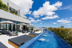 a swimming pool with chaise lounge chairs and a building at Southwest Grand Hotel in Naha