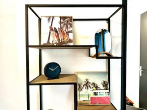 a shelf with a clock and other items on it at Le Muretain parking gartuit à proximité in Muret