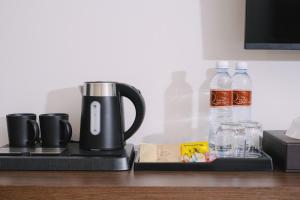 a coffee maker on a tray with bottles of water at Raya Hotel Krabi in Krabi