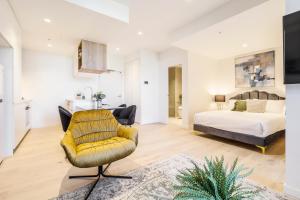 墨尔本Alluring Oasis in the Heart of South Melbourne的客厅配有床和黄色椅子