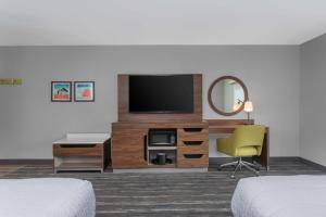 a hotel room with a television and a desk and a chair at Hampton Inn and Suites - Lincoln Northeast in Lincoln
