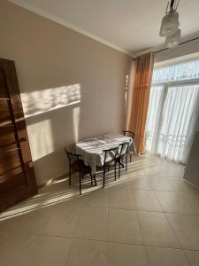 een eetkamer met een tafel en stoelen en een raam bij Апартаменти з балконом студія без окремої спальні in Truskavets +4 foto's