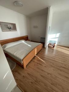 een slaapkamer met een groot bed en een houten vloer bij Апартаменти з балконом студія без окремої спальні in Truskavets