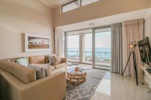 a living room with a couch and a view of the ocean at The Crystal Apartments in Cape Town