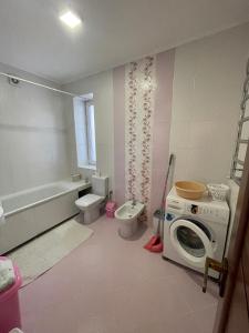 een badkamer met een wasmachine en een wasmachine bij Апартаменти з балконом студія без окремої спальні in Truskavets