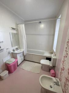 een badkamer met een bad, een toilet en een wastafel bij Апартаменти з балконом студія без окремої спальні in Truskavets
