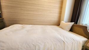 A bed or beds in a room at Platon Hotel Yokkaichi