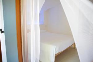 1 dormitorio pequeño con cama blanca y cortinas en Bianco Nuvola, en Montecchio