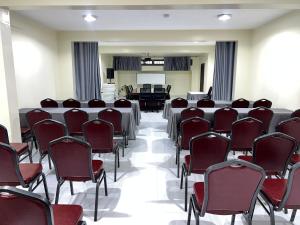 een kamer met rijen tafels en stoelen erin bij Speranza Hotel Entebbe in Entebbe