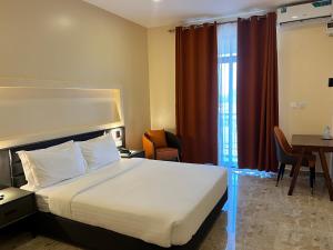 een hotelkamer met een bed, een bureau en een tafel bij Speranza Hotel Entebbe in Entebbe +85 foto's