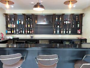 een bar met drie barkrukken in een kamer bij Speranza Hotel Entebbe in Entebbe