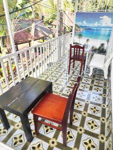 a porch with a bench and chairs on a tile floor at Hai Phuong Tuyen Guesthouse in Phu Quoc
