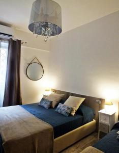 sypialnia z łóżkiem z niebieską pościelą i żyrandolem w obiekcie B&B Fiera Inn w Bolonii