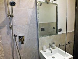W łazience znajduje się umywalka oraz prysznic z lustrem. w obiekcie B&B Fiera Inn w Bolonii