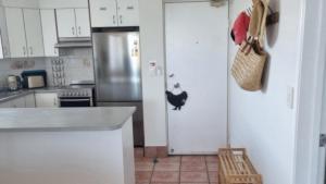 a kitchen with a refrigerator with a chicken on the door at #1 Seascape, Golden Beach Waterfront Location in Golden Beach