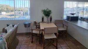 a living room with a table and chairs and a kitchen at #1 Seascape, Golden Beach Waterfront Location in Golden Beach