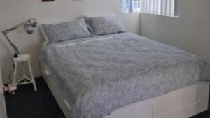 a bed in a room with a lamp and a bed sidx sidx sidx at #1 Seascape, Golden Beach Waterfront Location in Golden Beach +2 photos