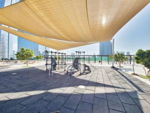 a large yellow umbrella on top of a building at HARF5110-Luxury 1BR w pool & GYM in Abu Dhabi