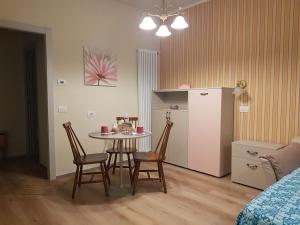 a small kitchen with a table and chairs and a refrigerator at MoMa Home Villasanta Monza Park in Villasanta