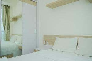Ένα ή περισσότερα κρεβάτια σε δωμάτιο στο Comfy and Nice Studio at Tree Park City BSD Apartment By Travelio +9 φωτογραφίες