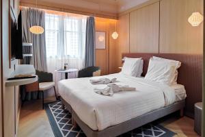 a hotel room with a large bed with towels on it at Aparthotel AMMI Nice Lafayette in Nice