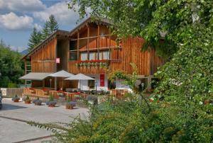 un bâtiment avec des tables et des parasols devant lui dans l'établissement La Bercia Dolomites Chalet, à La Villa