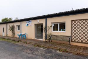 a building with a bench and a table on a porch at Petit appartement in Saint-Gildas-de-Rhuys