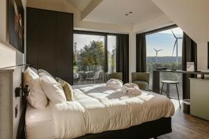 迪南CC Nomie Hôtel Restaurant的卧室里有一张白色的大床和一个阳台