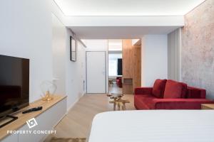a living room with a red couch and a tv at Cortina Concept Studio 128 in Voluntari