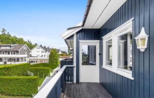 una casa blu con una porta bianca e un balcone di Stunning Apartment In Kristiansand S a Kristiansand