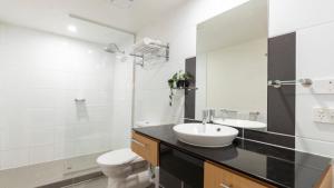 a bathroom with a sink and a toilet and a mirror at Lovely Studio Apartment Overlooking Golf Course! in Pelican Waters