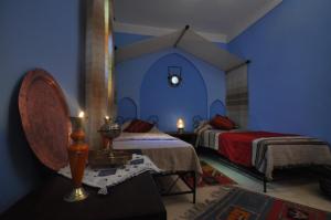 1 dormitorio con 2 camas y pared azul en Riad La Famille, en Marrakech