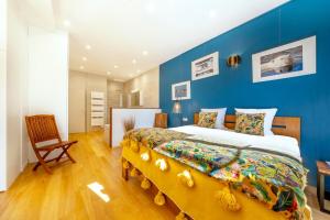 a bedroom with a large bed with a blue wall at Escale Rochelaise, gîte urbain avec SPA bain nordique et sauna tonneau in La Rochelle