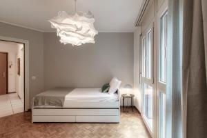 a bedroom with a bed and a chandelier at Pink Flat 2 by Quokka 360 - At the border of Switzerland in Chiasso +22 photos